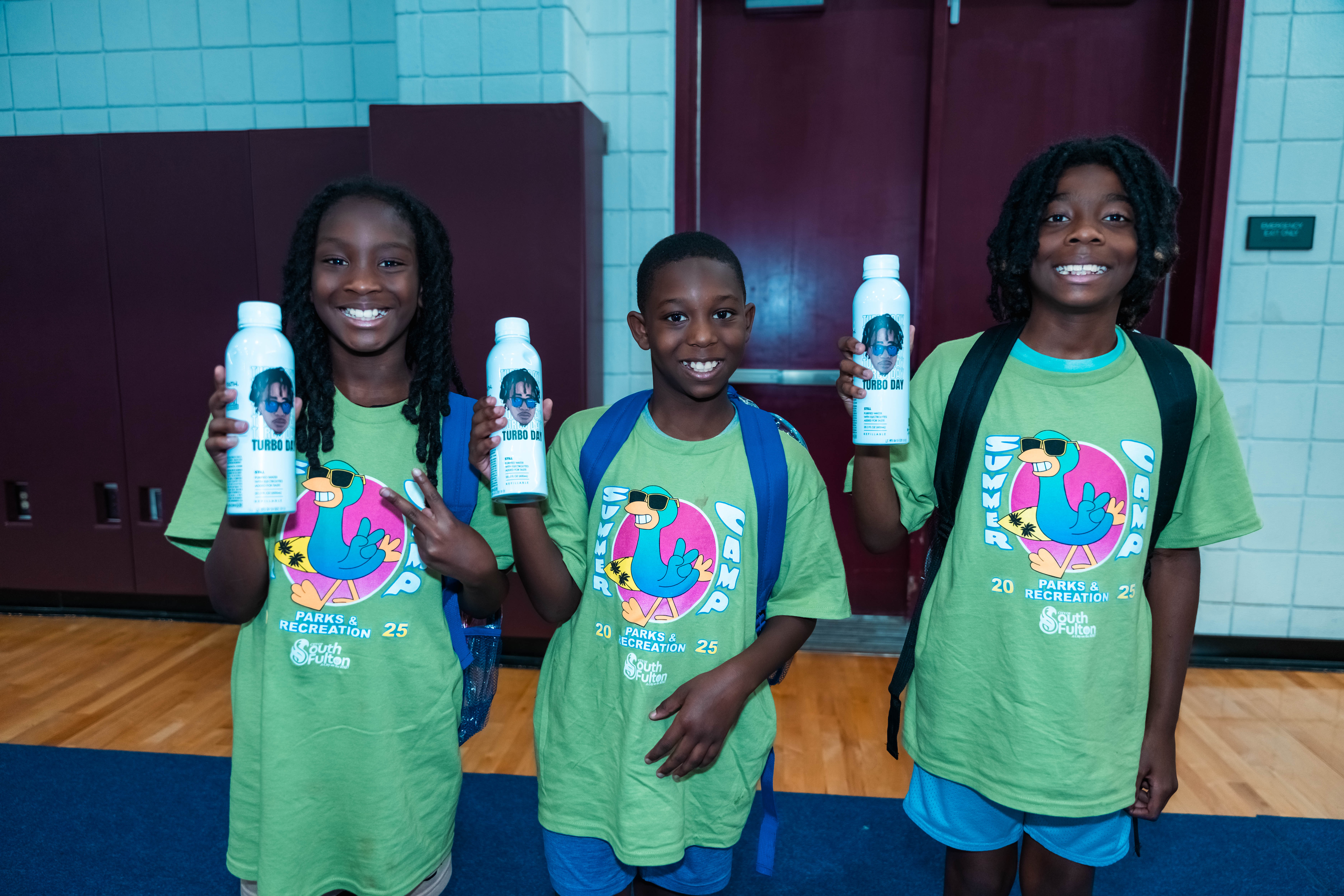 Kids holding Turbo Day water bottles